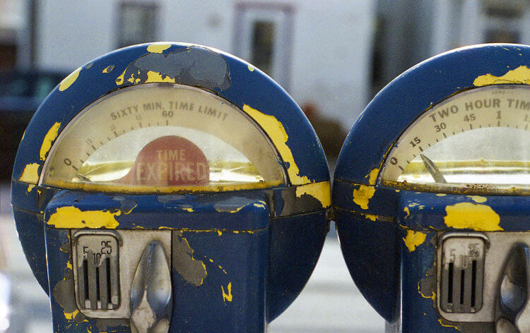 Two old parking meters are painted blue and yellow.