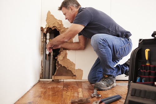 A man in blue shirt repairing home